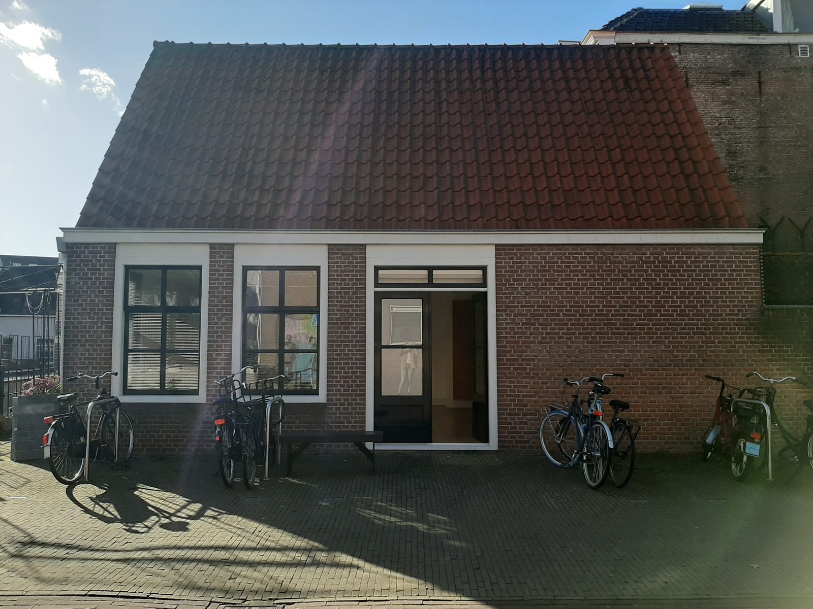 Het bakstenen achterpand van Shawna’s Brow Boutique met fietsen ervoor