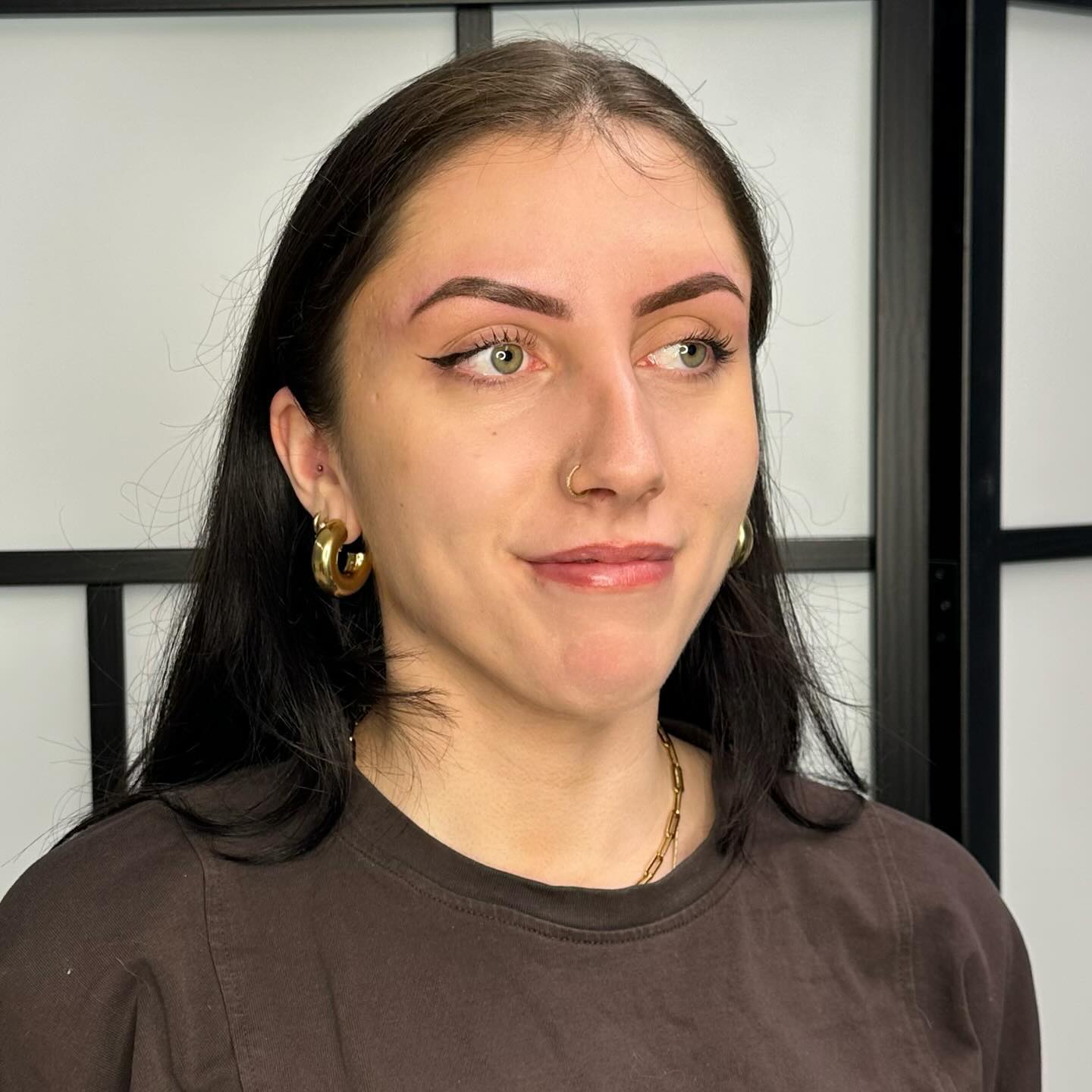 Klant met gestylde wenkbrauwen en eyeliner in de salon